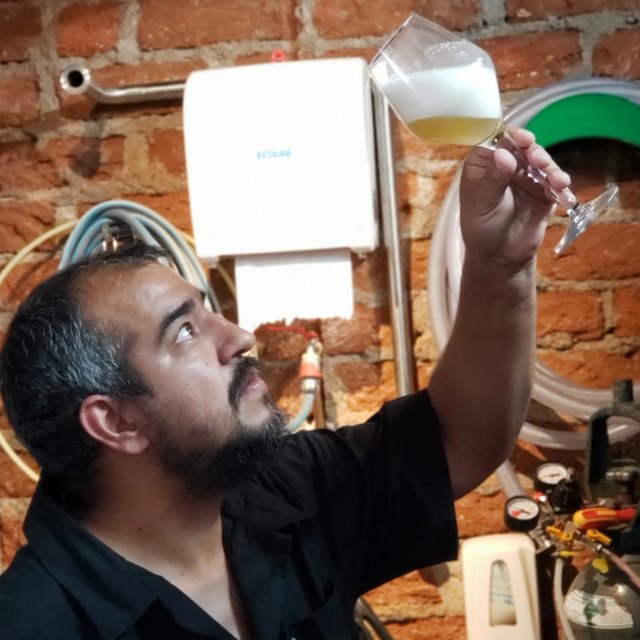 Carlos Farías evaluando una cerveza a contraluz